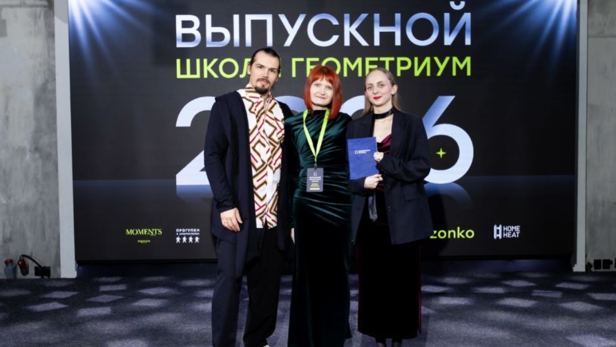 Студентка школы Геометриум с дипломом на фоне выпускного банера 